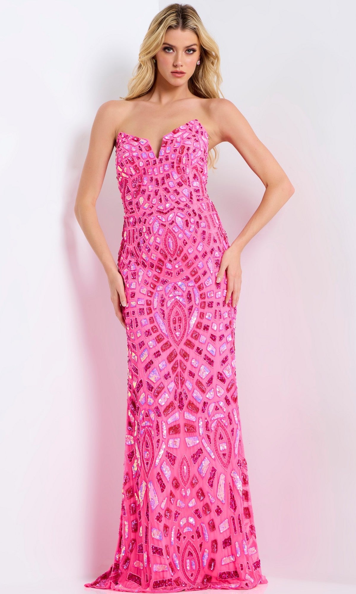 Woman wearing the Jovani 46938, a strapless, floor-length prom dress in fuchsia with geometric sequin patterns, stands against a light background.